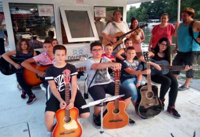 Zoran Ilić, učitelj gitare u školi “Gitarta” kaže da je odlučio da polaznicima najmlađe grupe priredi performans kako bi im pokazao gde sve gitara može da se svira